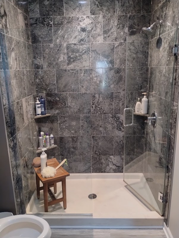 Custom marble tile shower installation by Robinhood Home Services — concrete board, tile, and recessed lighting